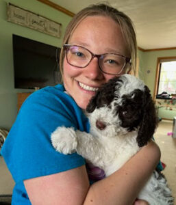 Rachel Kairys headshot holding a black and white dog