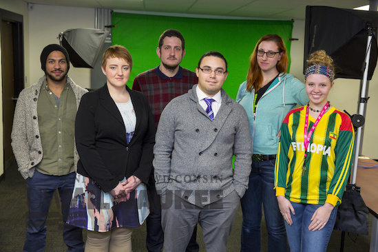 Six students stand together for a photo in front of a green screen.