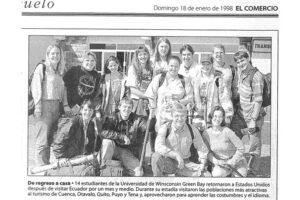 Scan of a newspaper section (El Comercio, 1998). Shows a photo of a group of students with the caption "De regreso a casa. 14 estudiantes de la Universidad de Wisconsin Green Bay retornaron a Estados Unidos después de visitar Ecuador por un mes y medio. Durante su estadía visitaron las poblaciones más atractivas al turismo de Cuenca, Otavalo, Quito, Puyo y Tena y, aprovecharon para aprender las costumbres y el idioma." 