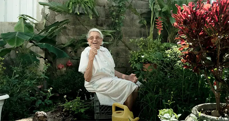 an elderly person sitting in a garden