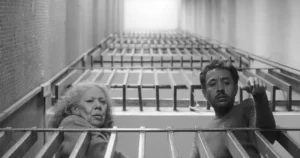 two people looking down from a balcony