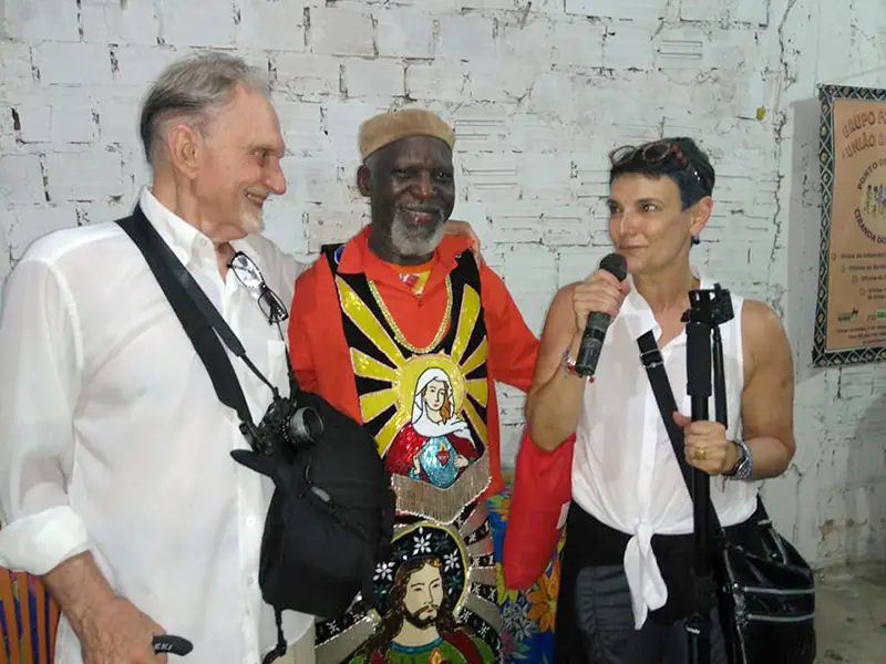 Professor Simone Ferro (Dance; right) and her longtime research partner Meredith Watts (Political Science; left) pictured at a baptism ceremony for one of Bumba-meu-boi's distinctive ox puppets. The two worked with Marcello to preserve their ethnographic research for a new generation of scholars