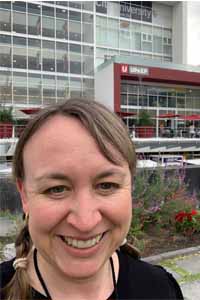 Professor Jessica Nelson in a selfie outside of a sleek, modern university building