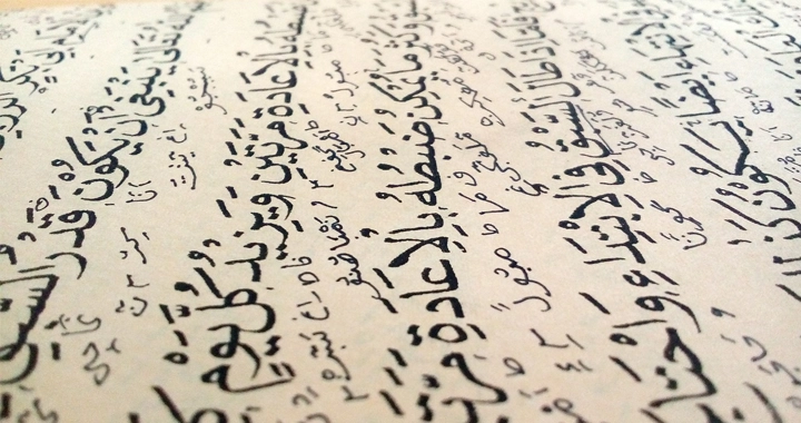 Arabic writing in black ink written across cream-colored paper