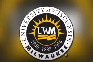 The UWM logo sits in the middle of a black circle surrounded by a gold sunburst. There is a white ring around the black circle with letters in the ring reading University of Wisconsin Milwaukee.