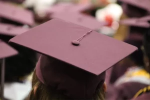 Photo shows the top of a young woman's graduation mortarboard cap from the back.