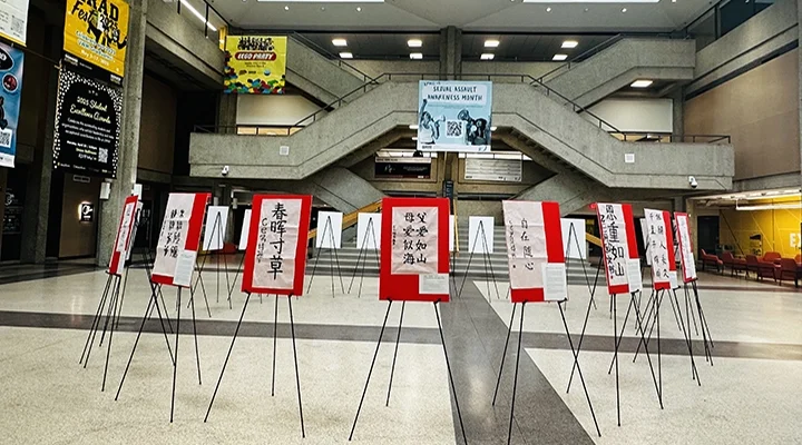 A circle of red signs on easels stands in a large room on a tiled floor. The signs contain black Chinese calligraphy.