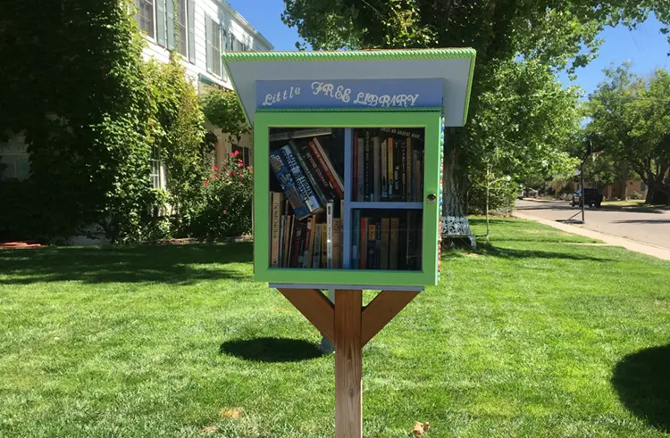 A little free library - a glass-fronted box with an angled roof filled with books for people to take or leave