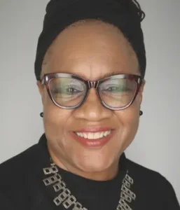 A headshot of a Black woman wearing glasses and a black head scarf.