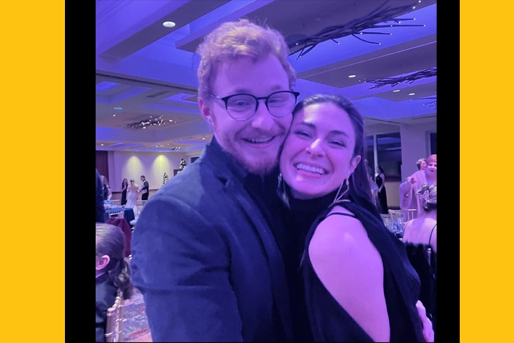 A young white man and woman hug each other at a wedding reception.