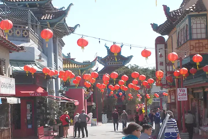 photo of a street with red paper lanterns hanging over it