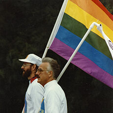 Two men carrying a Pride flag