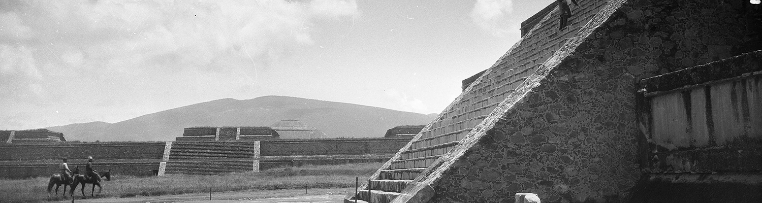 Image of two men in two horses surrounded by stepped pyramid like structure