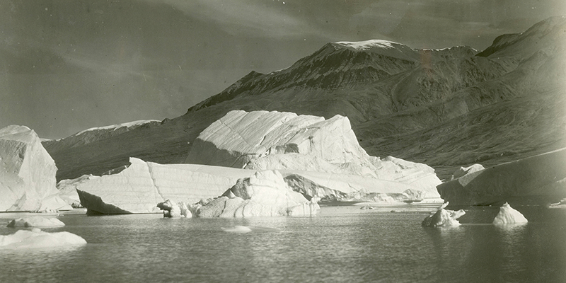 Decorative example image of a Louise Arner Boyd photograph of an iceberg, water, and mountains