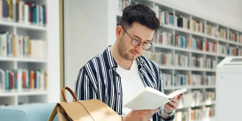 person reading book in library