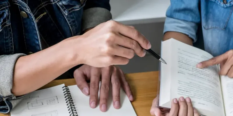 closeup of hands handling papers at a desk