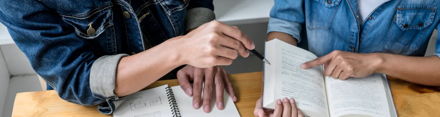 closeup of hands handling papers at a desk