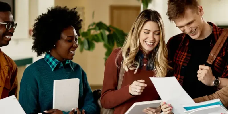 students gathered around a looking at papers