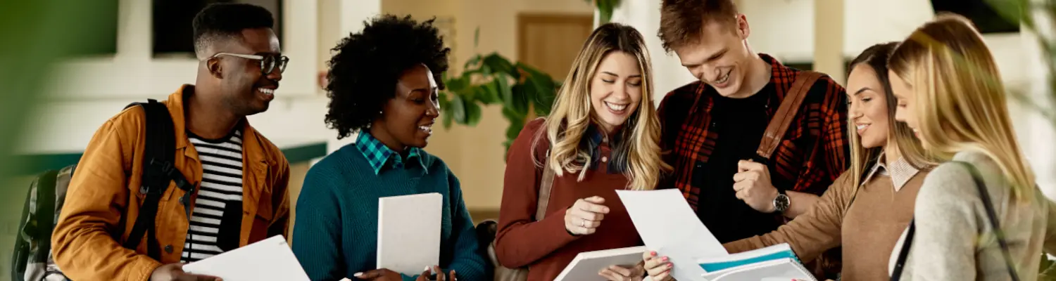 students gathered around a looking at papers