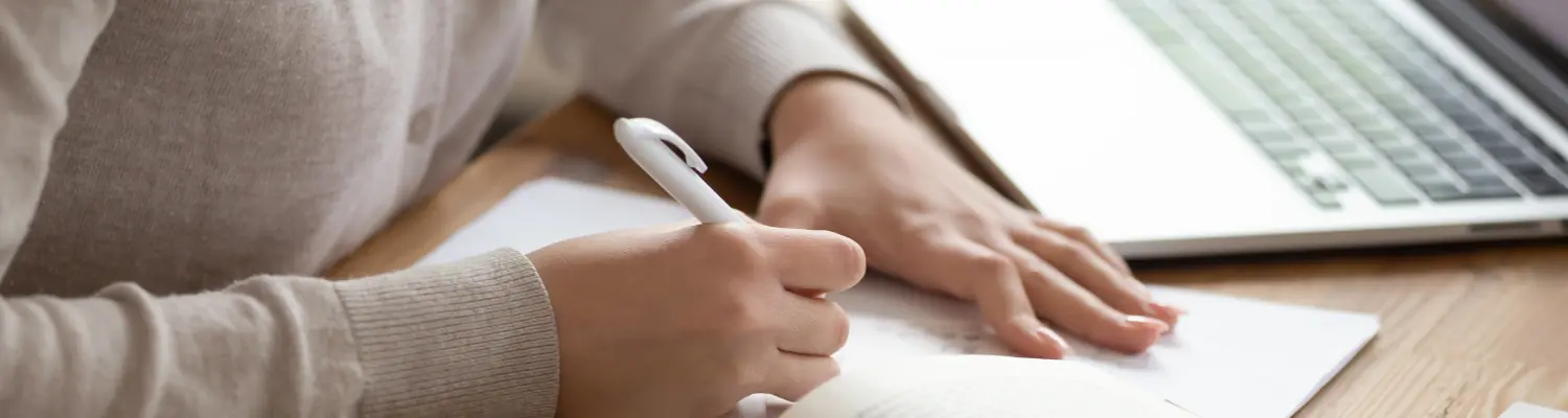 closeup of hands writing on paper