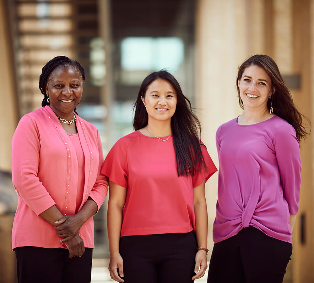 Three diverse women stading in a hallway smiling