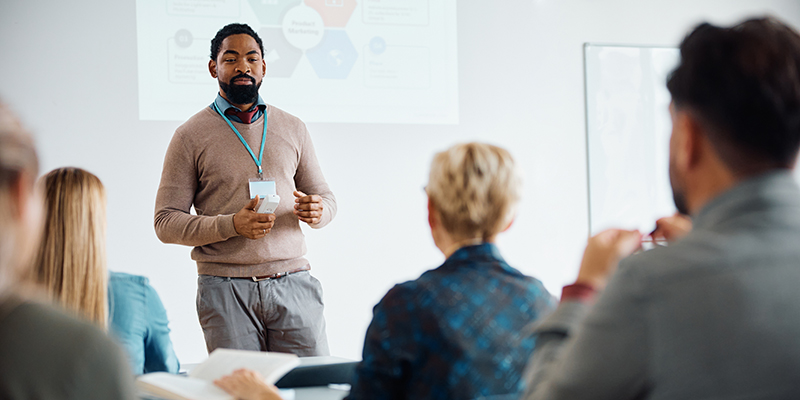 Black man speaking to a group of educators