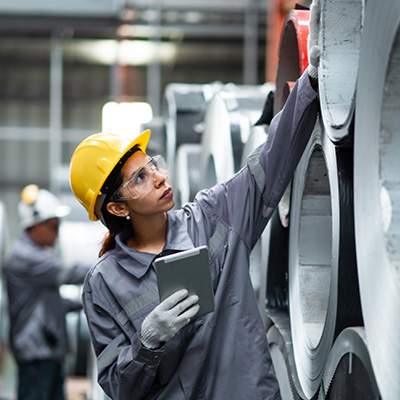 A woman inspecting parts in a industrial setting
