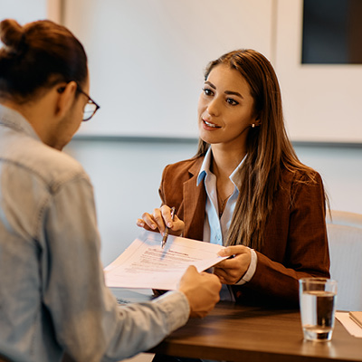 A human resources professional talking with another person about some documents.