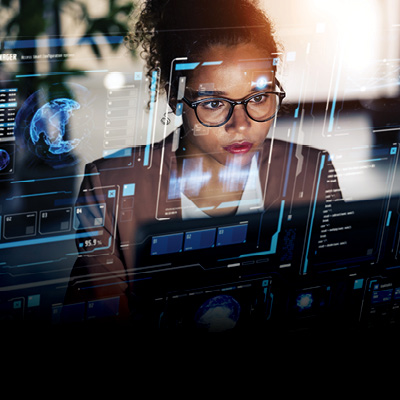 A woman working on a computer, overlayed on the image is a transparent image of the computer screen