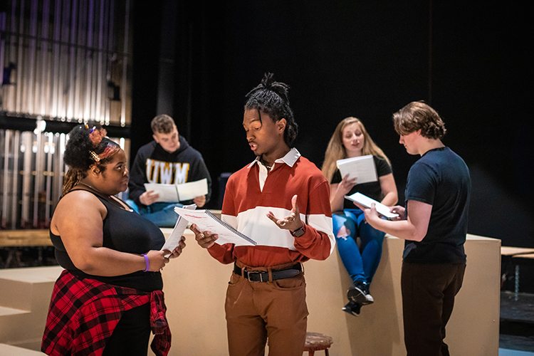 A group of theatre students rehearsing on stage.