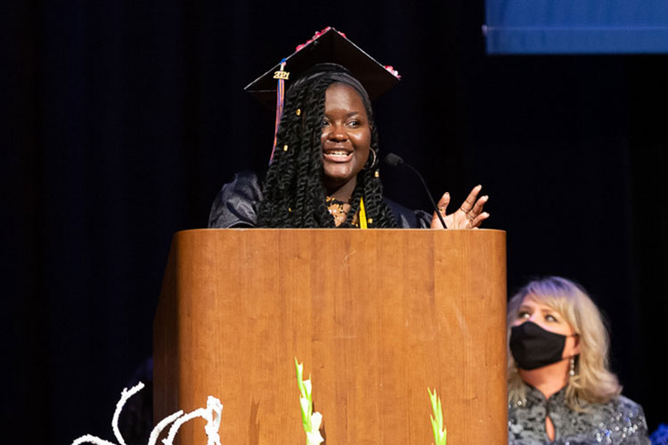 A woman speaks at a graduation ceremony