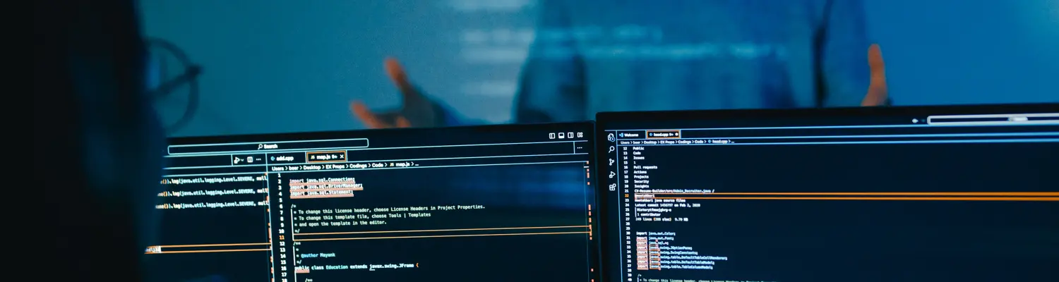 monitors with code and person standing behind as if talking to user