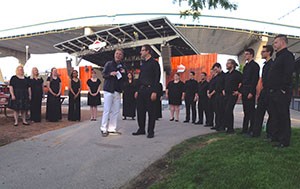 Todd Hicks, of TMJ4, interviews the UWM Concert Chorale at Summerfest the morning after the choir perfomed with the Rolling Stones. (UWM Photo/Rebecca Ottman)