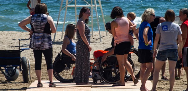 Volunteers Saturday created a temporary access path to Bradford Beach. A fundraising effort is underway to help buy more wheelchairs that are designed for use in sand and the county parks department says it will implement permanent access to the beach. (UWM Photos/ Kenny Yoo)