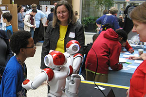 UWM’S Susan McRoy, center, and Vanessa Radlinger, right, demonstrated Nao robots at the 2016 MPS STEM Fair April 21 at the Milwaukee County Zoo. 