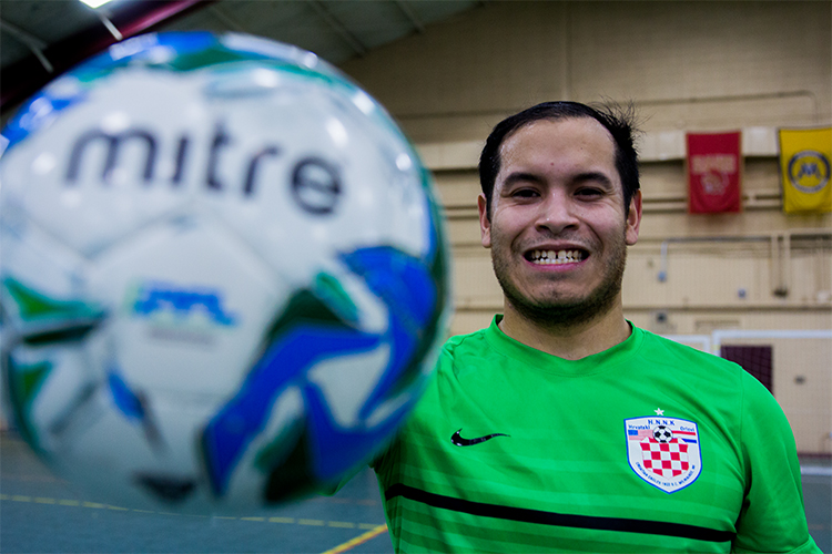 Taylor Layton smiles for a portrait holding a soccer ball.