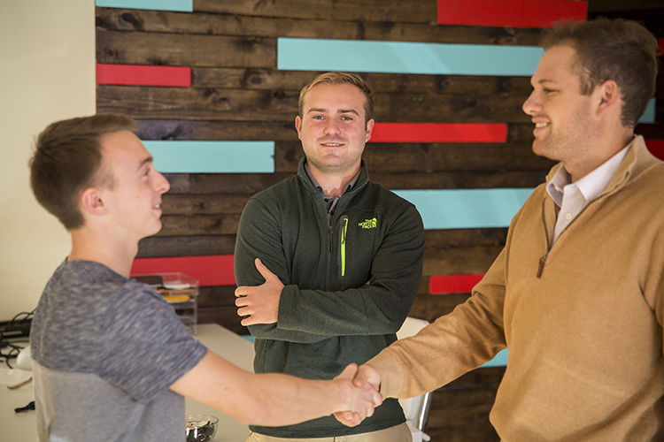 Cody Dobberstein's business idea is to link students with local businesses to give them ideas about future career opportunities. He's pictured here (center) with UWM student Collin Roberts (left) and Richie Burke, founder of GoGeddit, a local marketing firm in Bay View. (UWM Photo/Derek Rickert)