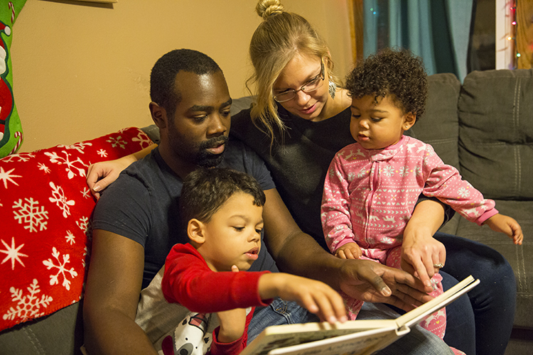 Amber and Jared Anderson read to their children, Wesley, 4, and Bay, 1. Family time competes with schoolwork time for the Andersons, both UWM seniors studying to be science teachers. (UWM Photo/ Derek Rickert)