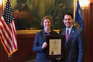 Rebecca Neumann, associate professor of economics at UWM, receives a 2016 Governor’s Financial Literacy Award from Gov. Scott Walker at the Wisconsin Capitol. (Submitted photo)