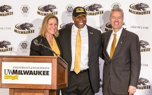 Amanda Braun, Patrick Baldwin and Mark Mone stand next to a podium on stage.