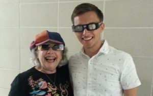 A woman and a man wearing solar eclipse viewing glasses.