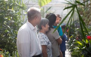 A family consisting of two grandparents, a mother and two sons explores the UWM greenhouse.