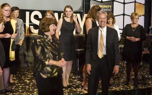 Borger and Mone stand in a group amid confetti as they laugh.