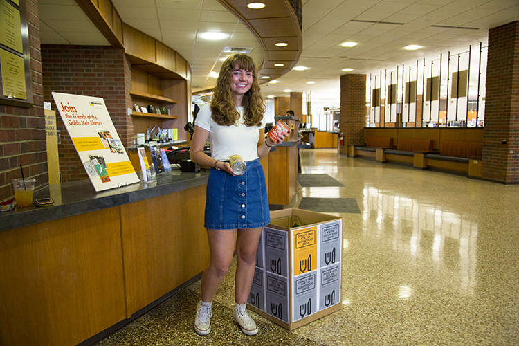 Alyssa Molinski is standing by food donation box in the Golda Meir Library.