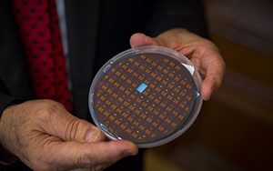 A man holds a disk containing numerous small sensors.