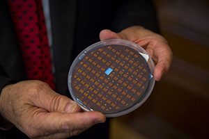 A man holds a disk containing numerous small sensors.