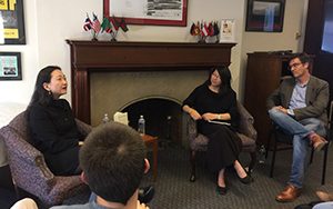 People sit in chairs while discussing books.