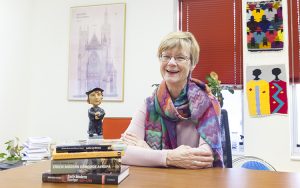 Merry Wiesner-Hanks sits at her desk with a Martin Luther bobblehead.