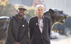 Carr and Robertson stand in front of the UWM Panther.