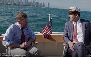 Egan and Kosta ride in a boat with the Chicago skyline in the background.
